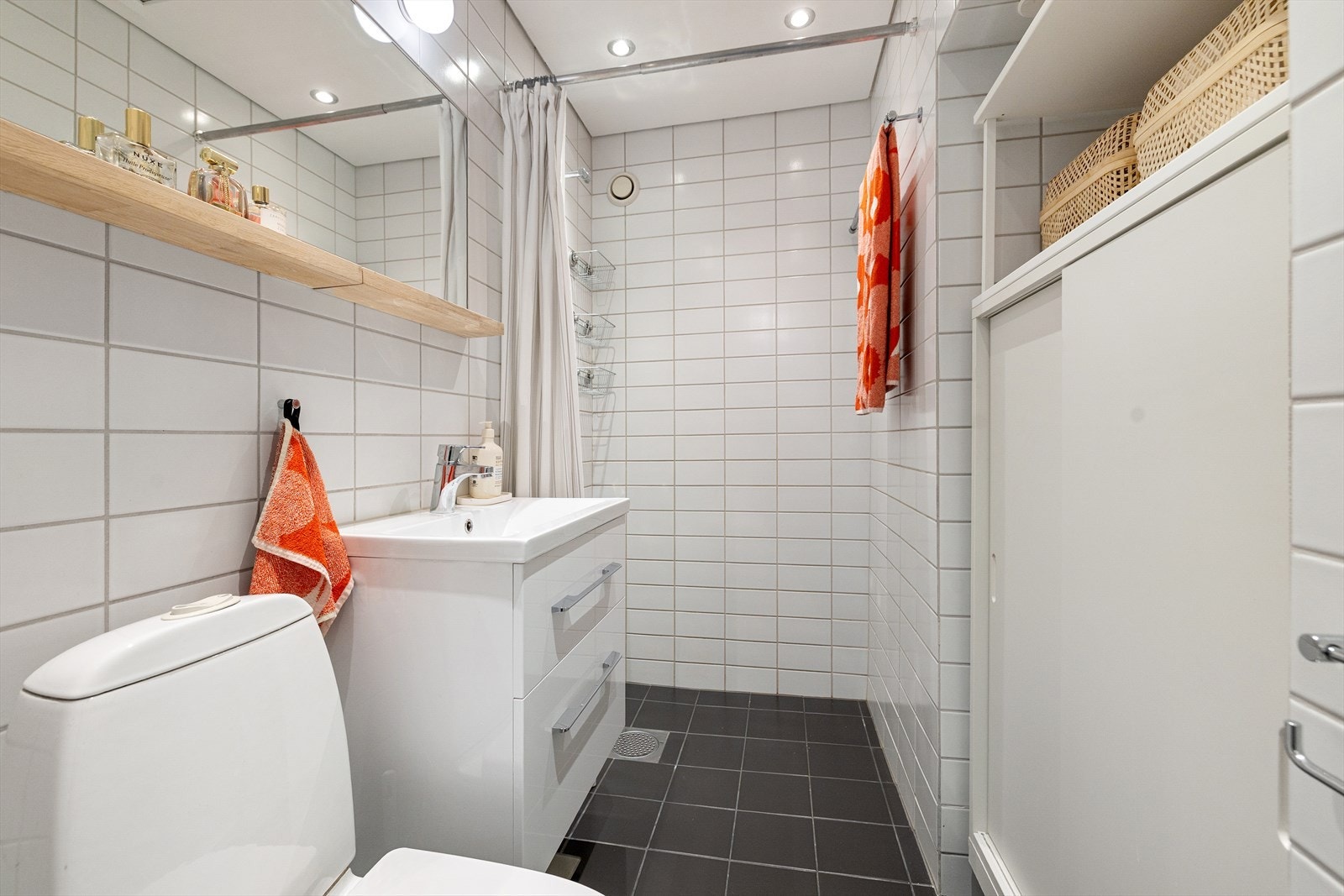 Praktisk flislagt bad med gulvvarme, naturlig avtrekk og opplegg for vaskemaskin. Innredet med servantskap med hvite fronter og keramisk servant. Luke i himling gir adkomst til teknisk loft. Galleribilde