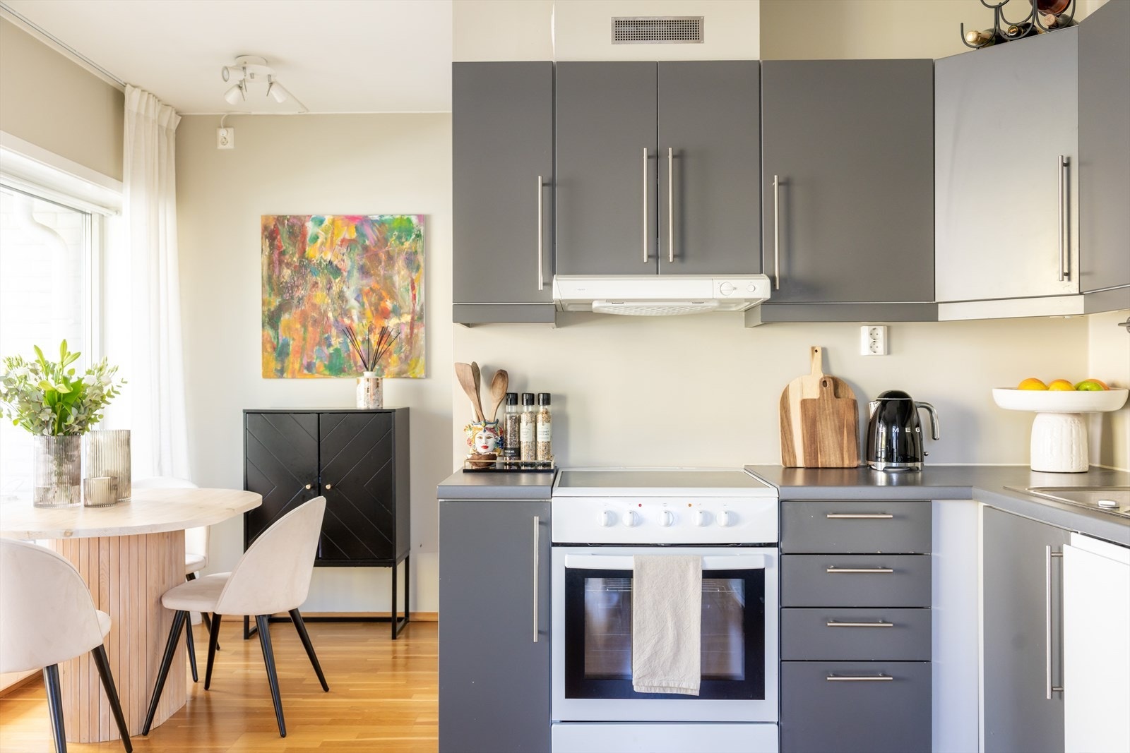 Kjøkkeninnredningen er bestående av grå, glatte fronter med benkeplate av laminat og nedfelt vaskekum. Galleribilde
