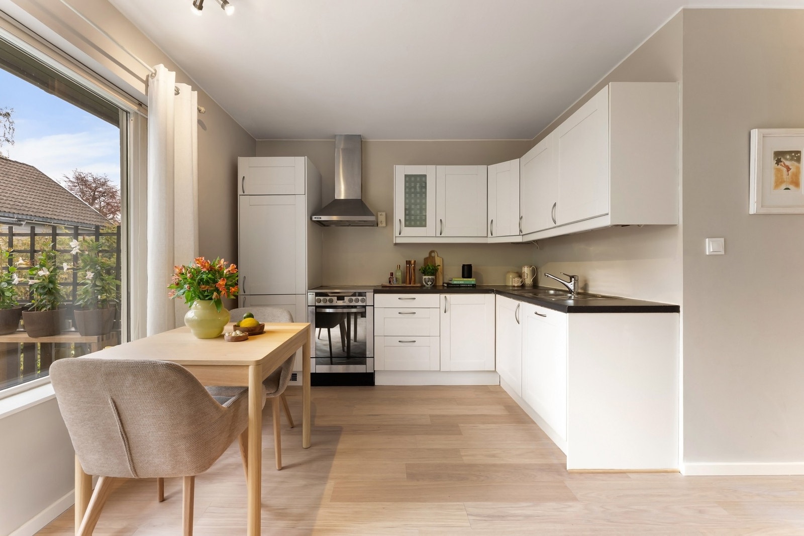 I en åpen løsning mot stuen har leiligheten et IKEA kjøkken fra 2004 med slette skapfronter og laminerte benkeplater. Kjøkkenfrontene ble malt opp i 2026. Galleribilde