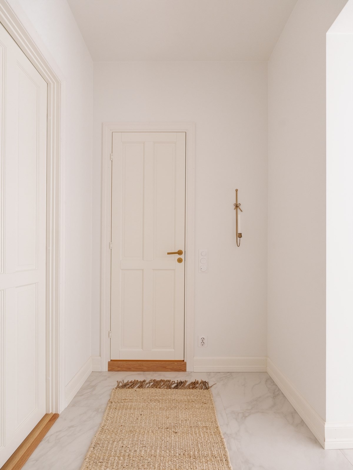 Innbydende yttergang med 60x60 fliser på gulv med varmekabler under. Legg merke til den klassiske døren med ekstra høyde og håndtak i messing. Galleribilde