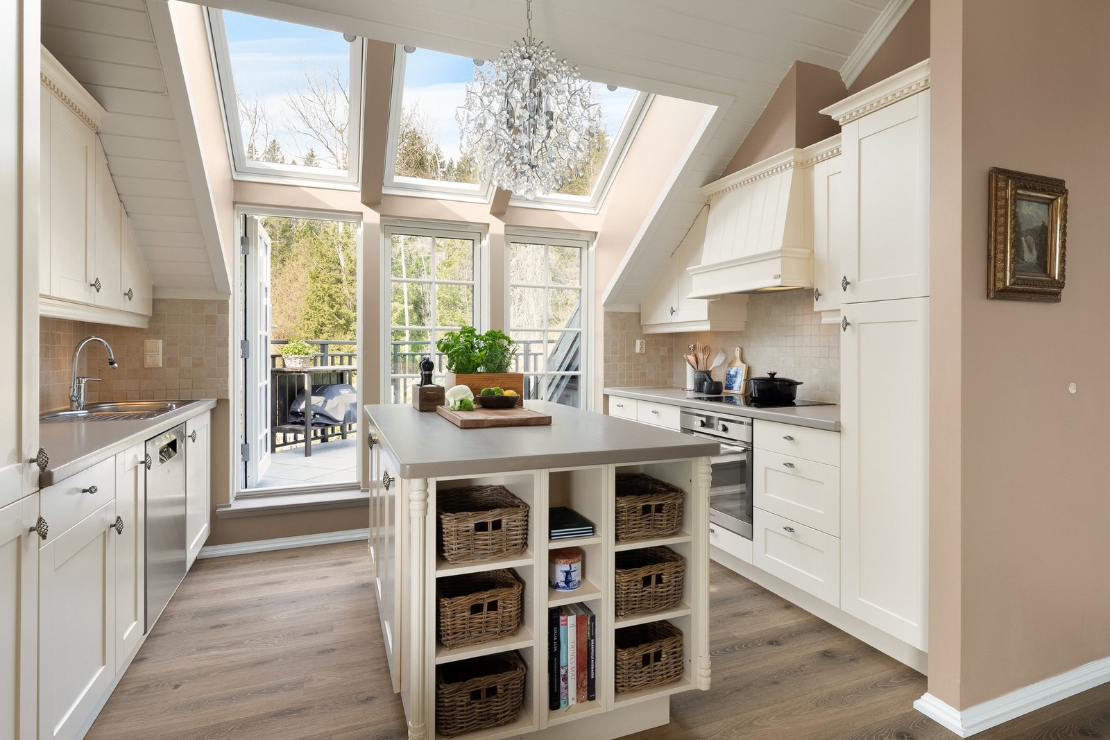 Integrerte hvitevarer som induksjonstopp, stekeovn, oppvaskmaskin og kjøl/frys, samt fliser over benk, god belysning og downlights under overskap. Galleribilde