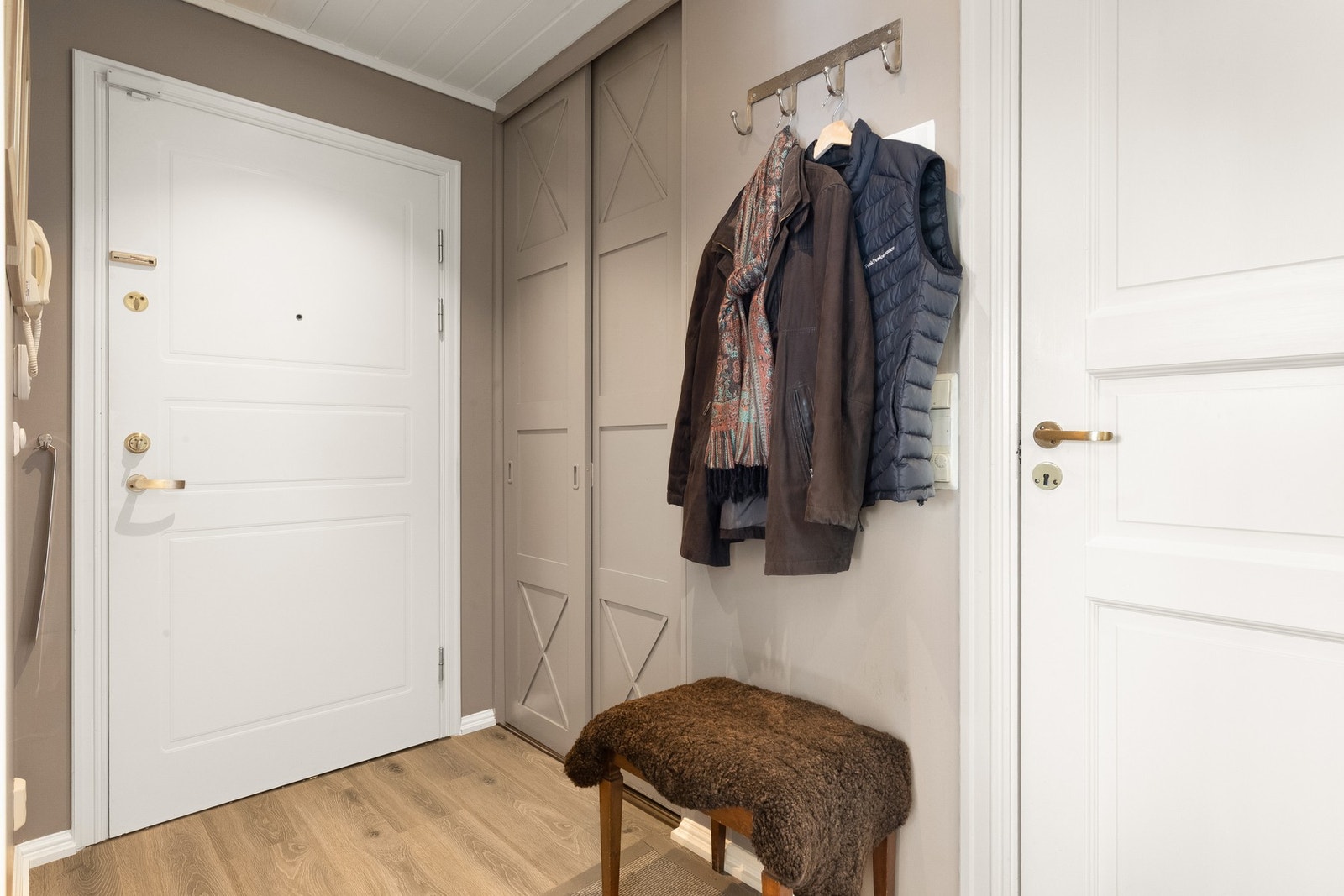 Praktisk entré med plass til yttertøy og sko. Skyvedørsgarderobe med gode oppbevaringsmuligheter, samt downlights i himling og dørtelefon med video. Galleribilde