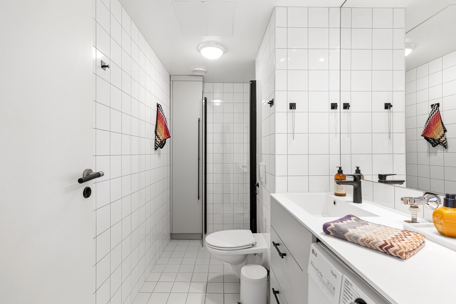 Pent, flislagt baderom med gulvvarme og opplegg for vaskemaskin. Galleribilde