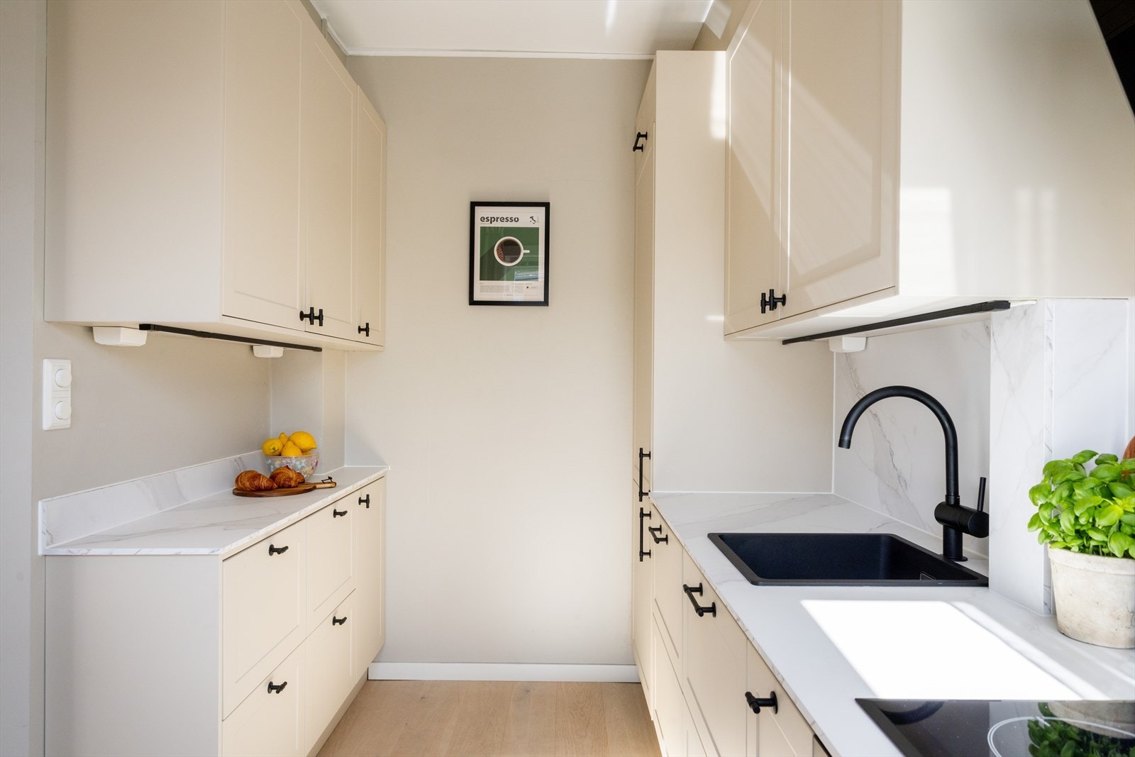 Kjøkkeninnredningen består av beige, profilerte fronter og laminat benkeplate med nedfelt vaskekum. Galleribilde