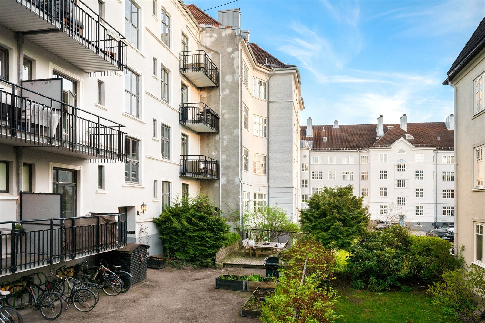 Skjermet og frodig bakgård med flere sitteplasser og praktisk sykkelparkering. Galleribilde