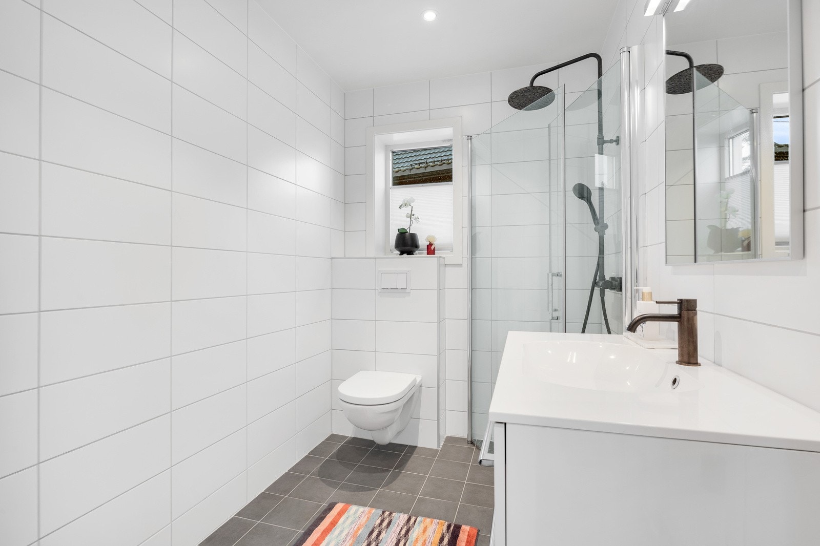 Planløsningen byr på to moderne bad med gulvvarme, downlights, vegghengt toalett og et dusjhjørne Galleribilde