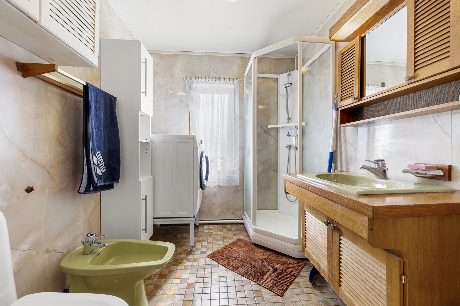 Badet i første etasje har fliser på gulv og vegger, elektriske varmekabler og opplegg for vaskemaskin. Galleribilde