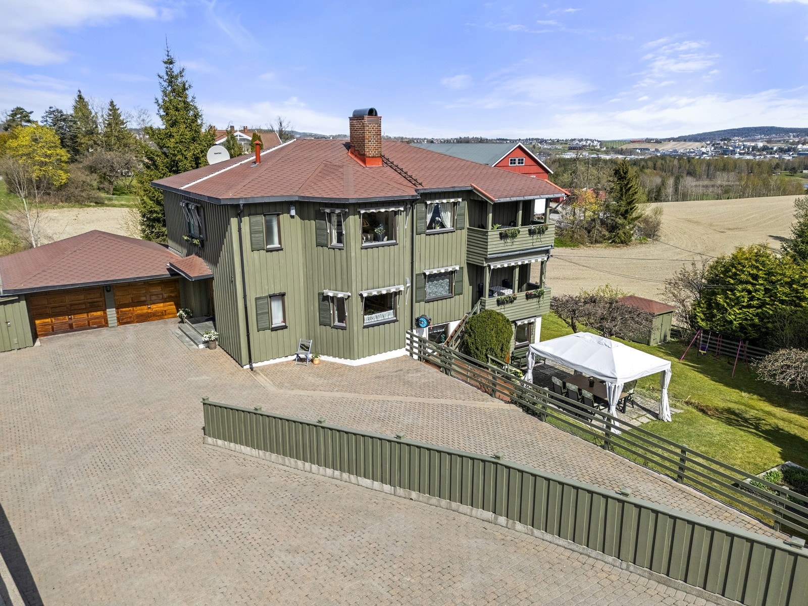 Eiendommen har en stor, pent opparbeidet tomt med hage, terrasse og en stor gårdsplass med belegningsstein. Galleribilde