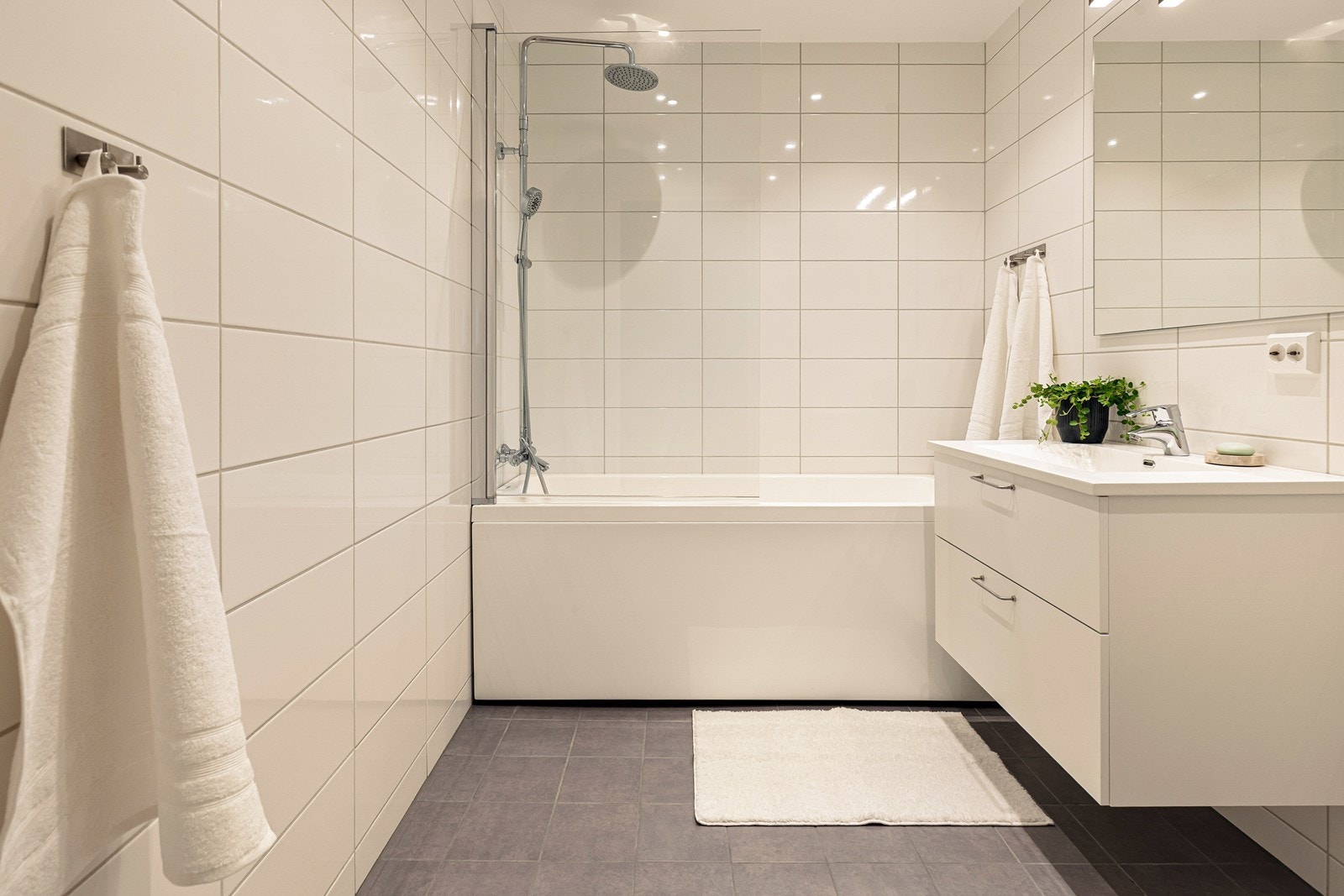 Badet i andre etasje har flislagte gulv med varmekabler, badekar med dusj og veggmontert toalett. Galleribilde
