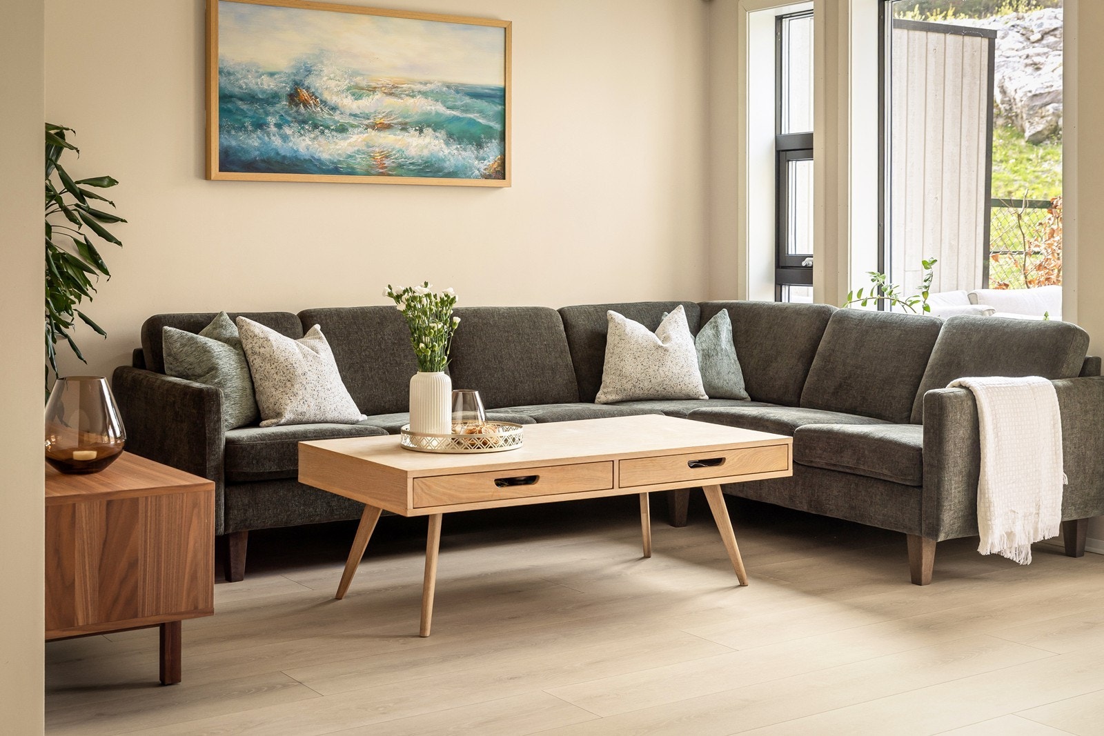 Gulvet i stuen har laminat, og de store vinduene slipper inn rikelig med naturlig lys. Galleribilde