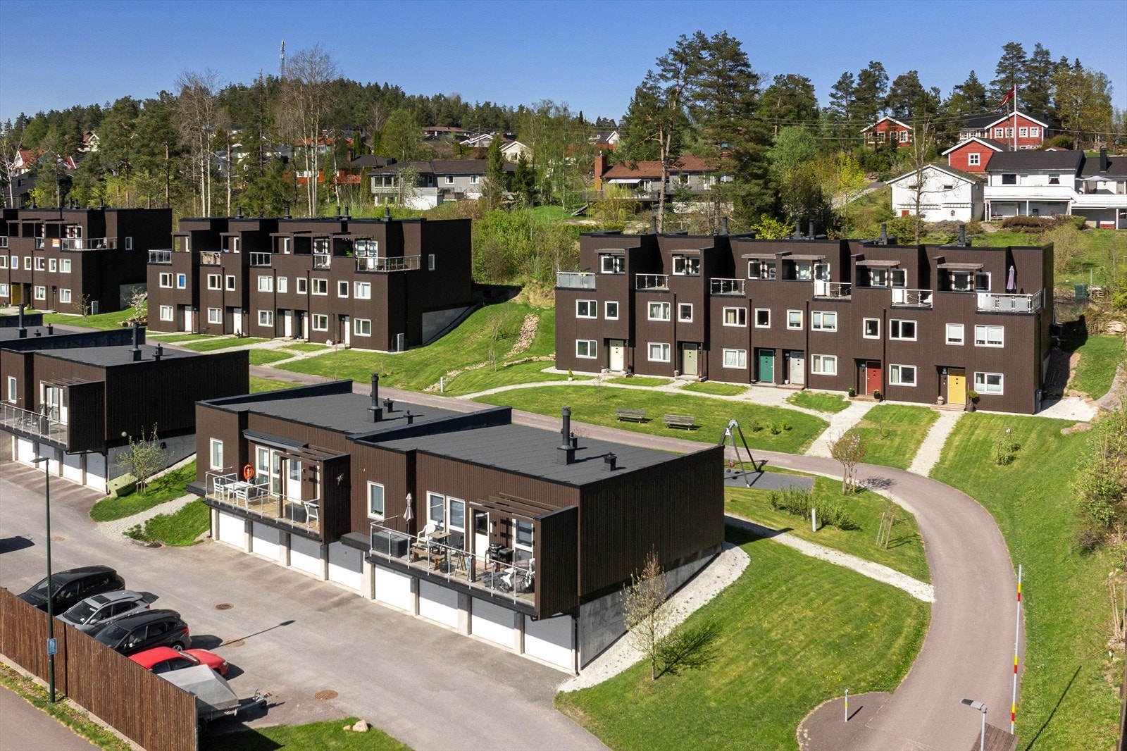 Borettslagets tomt er pent opparbeidet med asfalt, grus og plen. Galleribilde