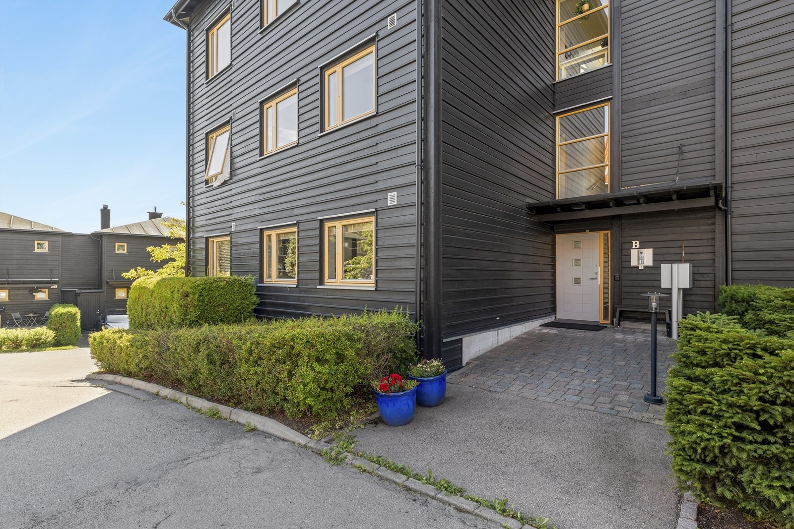 Inngangspartiet til 262B ligger er svært praktisk plassert rett ovenfor sameiets parkeringsplasser. Leiligheten disponerer garasjeplass i kjeller med heisadkomst Galleribilde