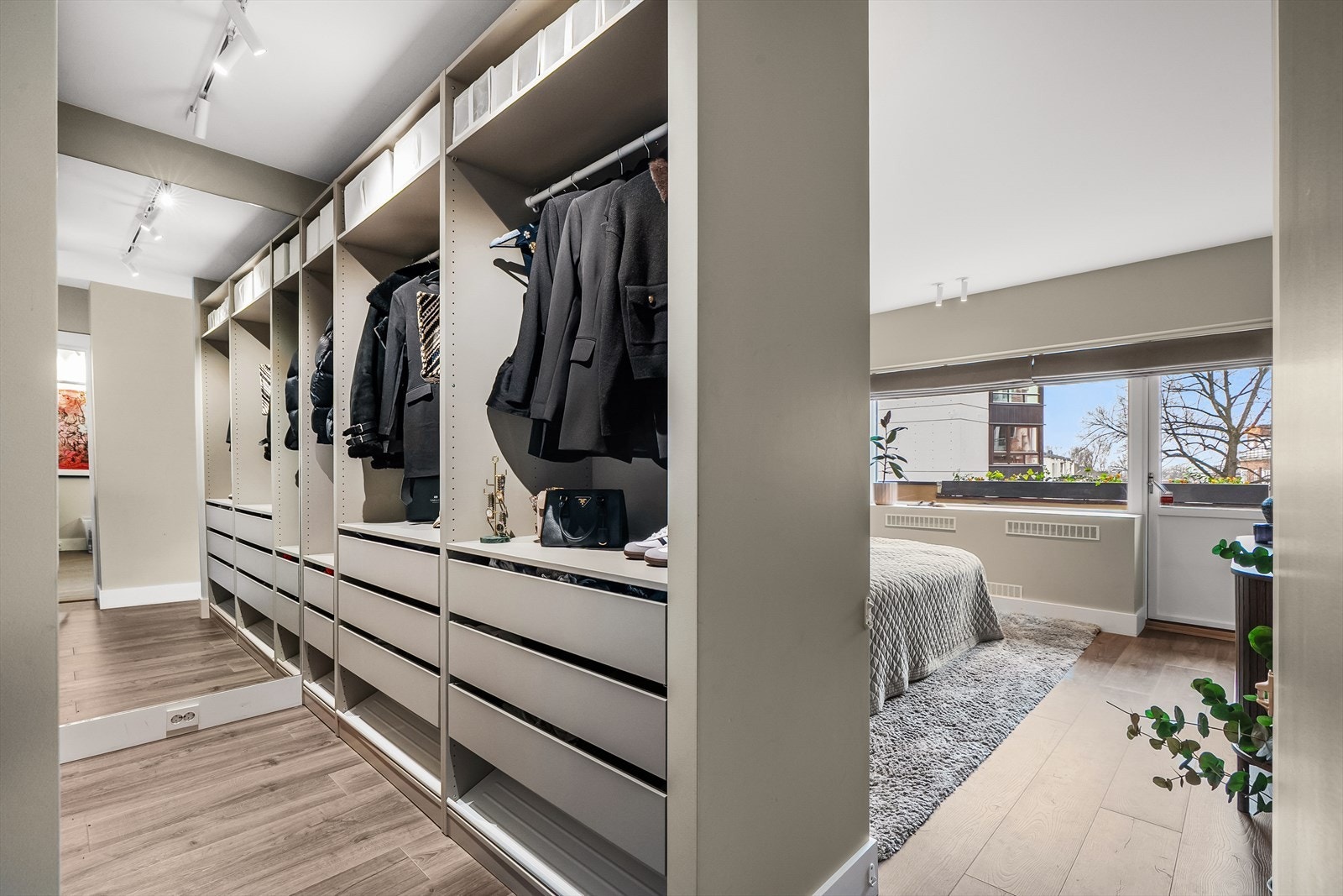 Stort walk-in closet med åpen garderobeinnredning og spesialbestilt helfigurspeil i enden. Galleribilde