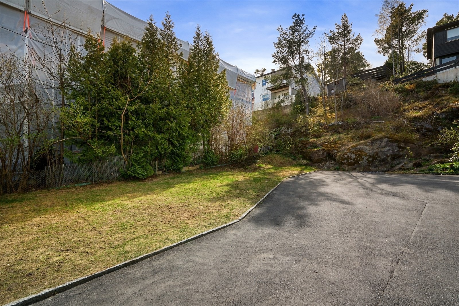 Stor, asfaltert gårdsplass med god plass til parkering for flere biler. Galleribilde
