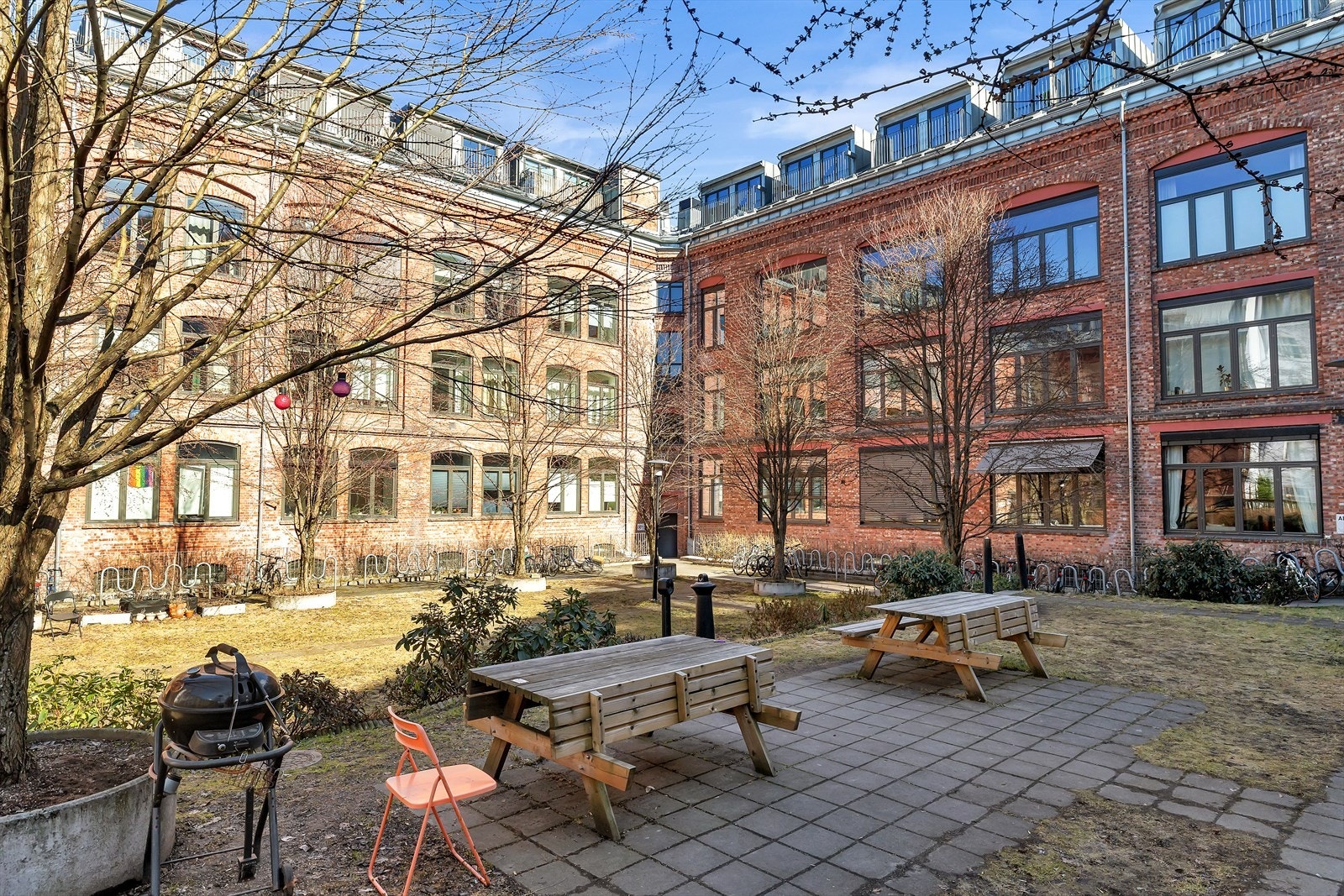 Leiligheten har tilgang til et felles uteområde med sitteplasser og beplantning. Galleribilde