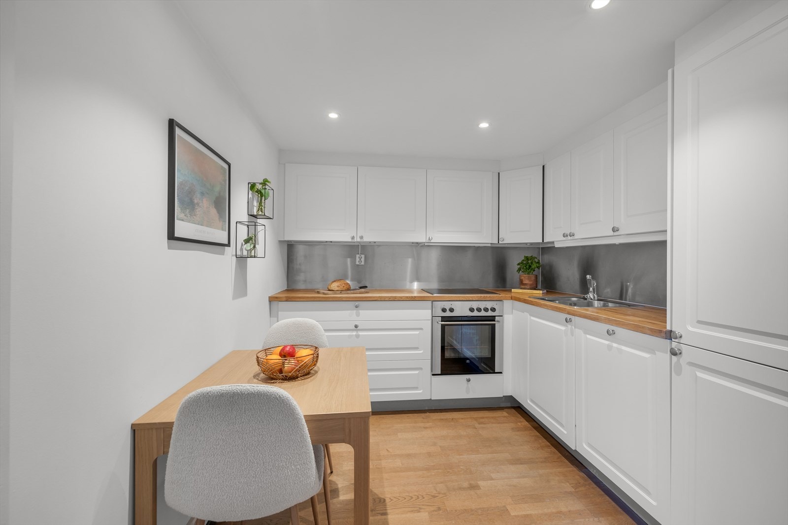 Kjøkkeninnredning fra Ikea fra 2007 med profilerte fronter fra 2023 og heltre benkeplate med oppvaskkum og 1-greps blandebatteri. Galleribilde
