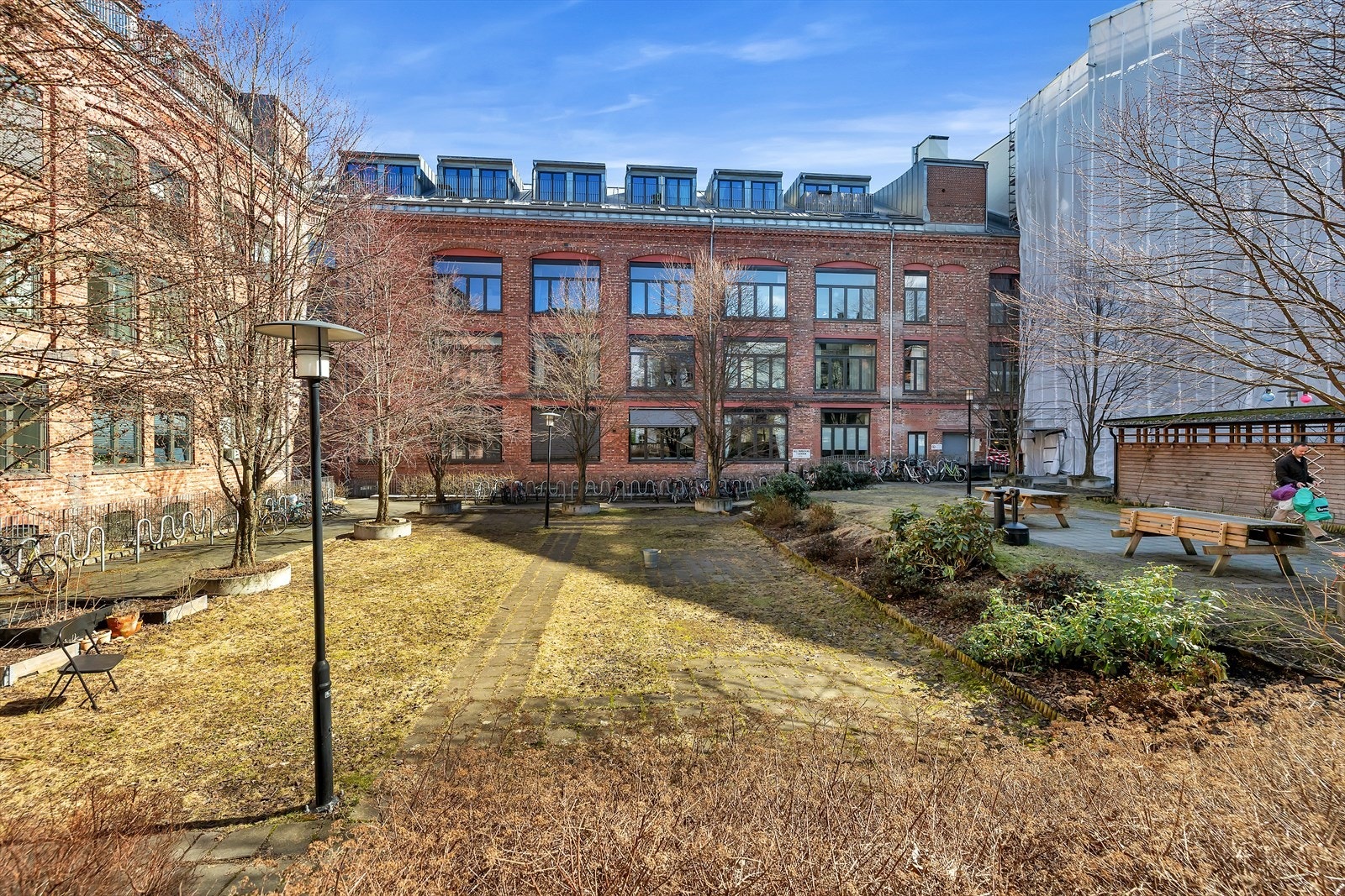 Leiligheten har tilgang til felles uteområde med beplantning og sitteplasser. Galleribilde