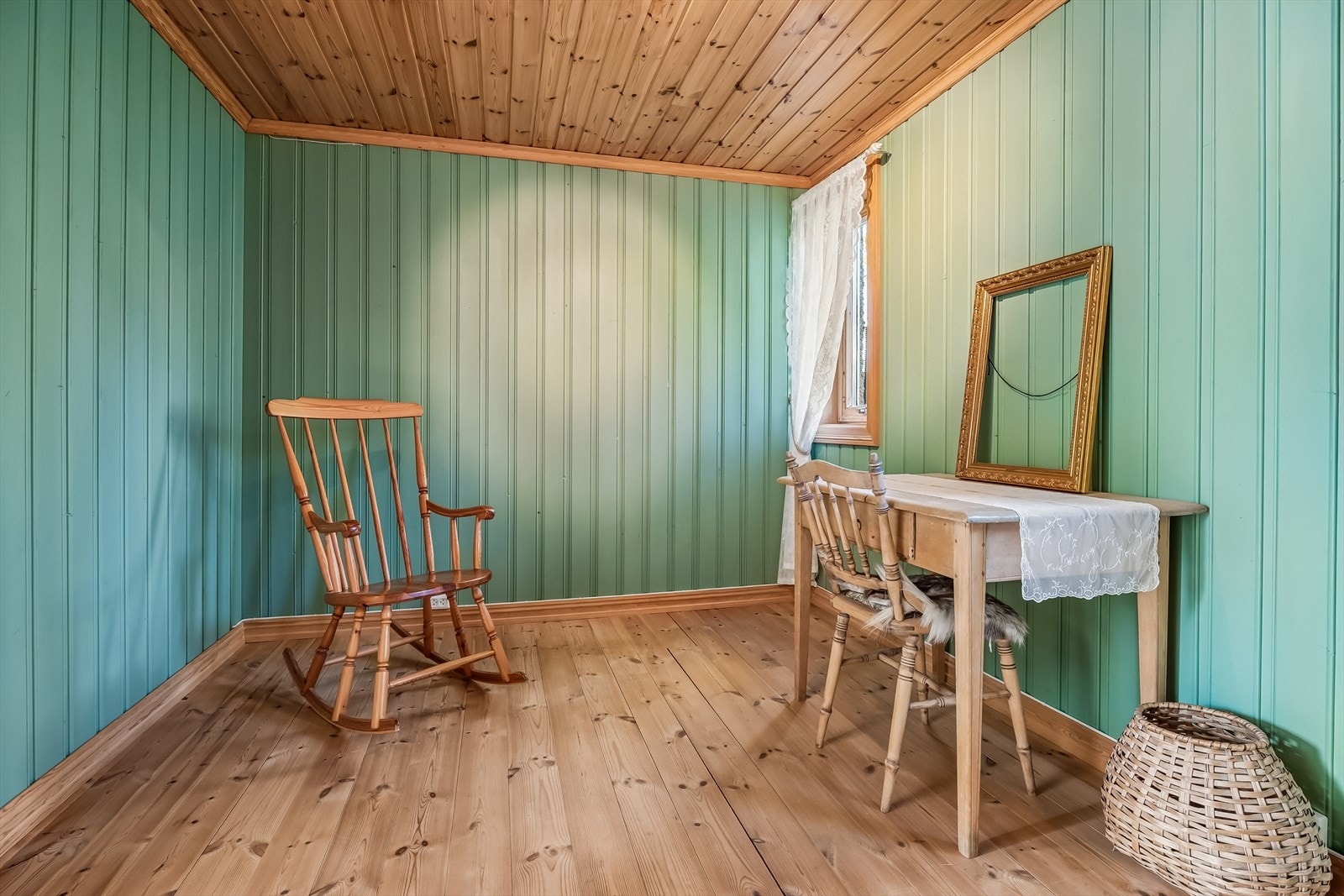 Soverom i kjelleretasjen med tregulv og panel på veggene. Galleribilde