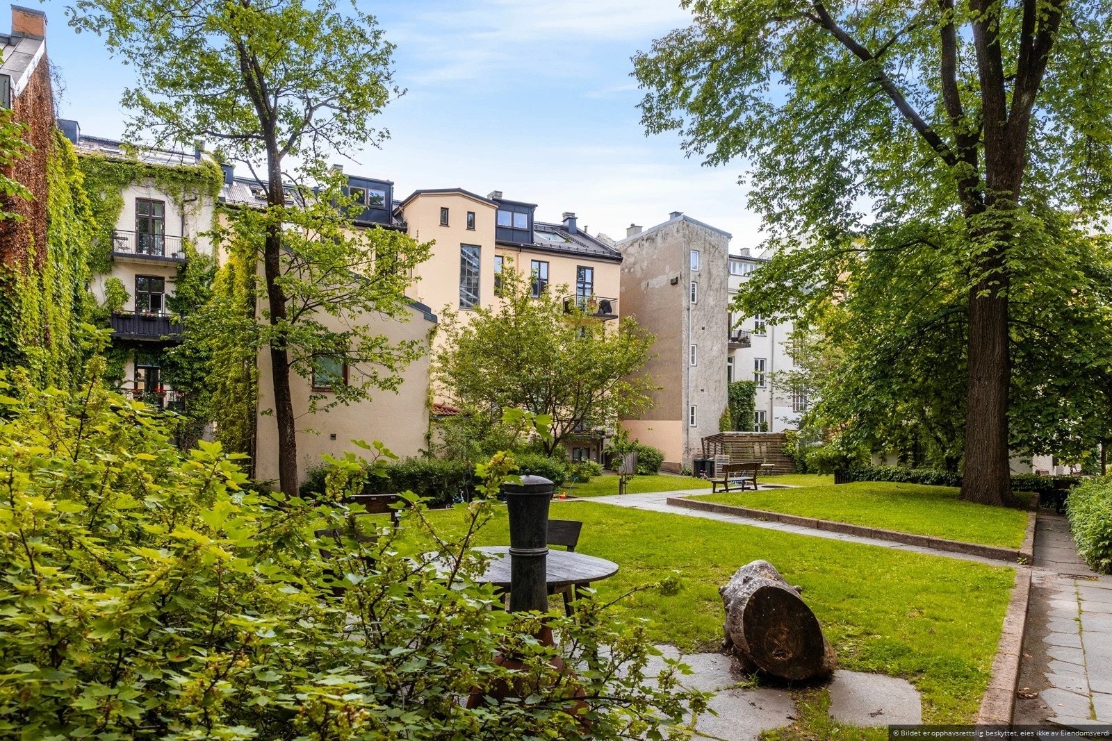 Den frodige bakgården byr på sittegrupper, grill og grønnsaksparseller, en grønn oase midt i byen Galleribilde