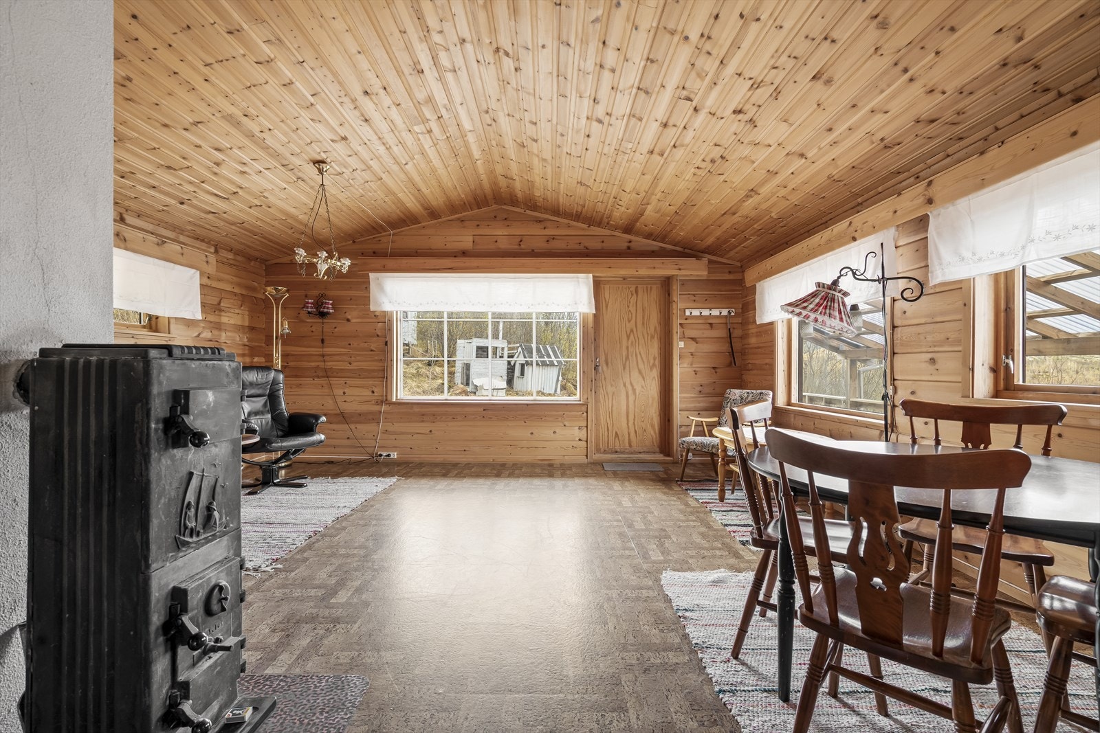 Stuen har god plass til både spisebord og sofagruppe. Vedovn sørger for varme og hygge. Galleribilde