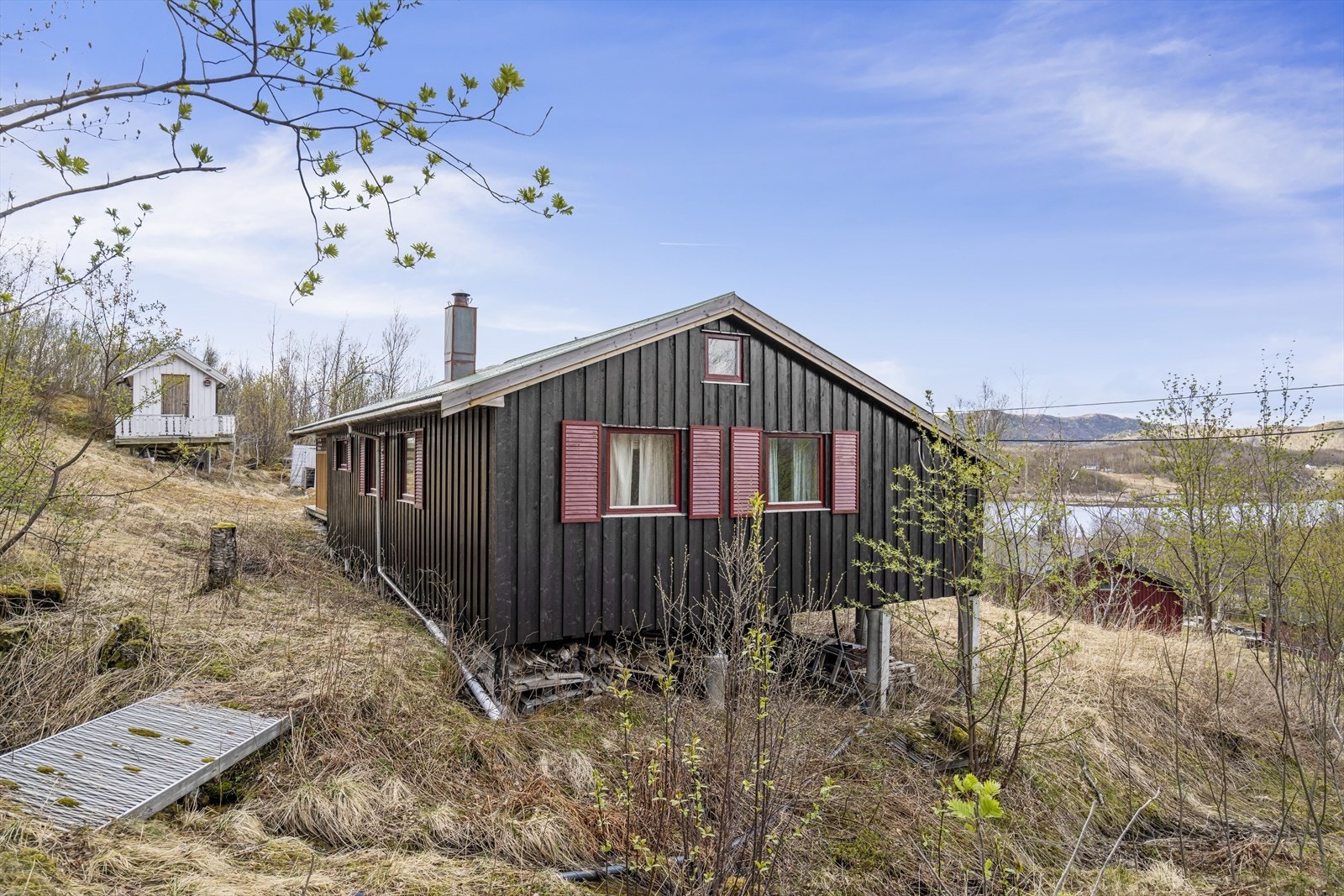 Fasaden har stående bordkledning, og hytta er fundamentert på pilarer. Galleribilde