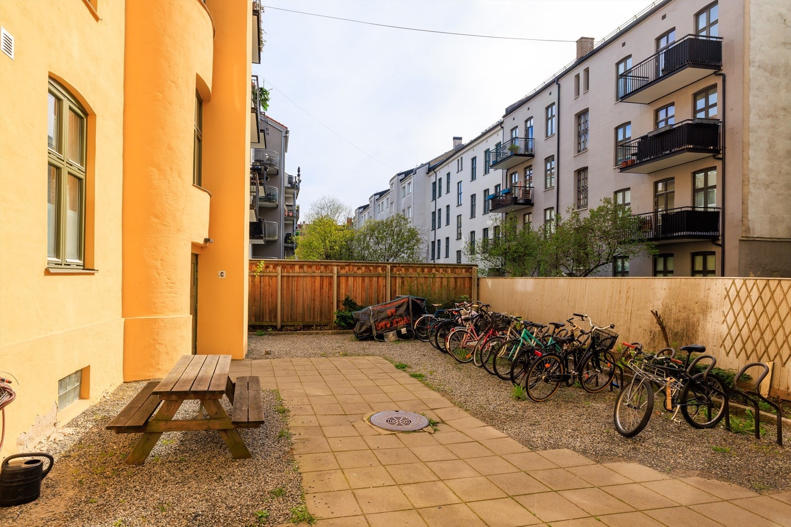 Felles gårdsrom med sykkelparkering og skjermet plassering bak bygården Galleribilde