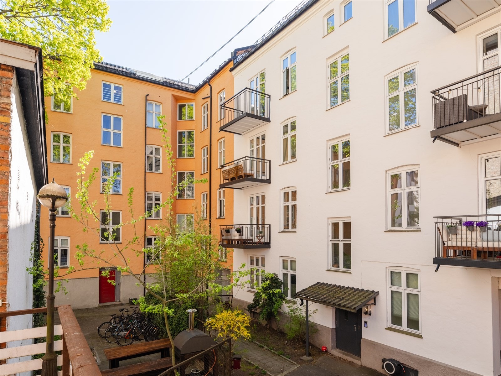 Hyggelig bakgård med beplantning, sittegrupper og sykkelparkering. Galleribilde