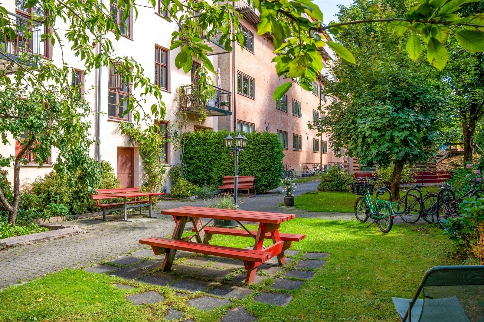 Frodig og idyllisk bakgård med hyggelige internveier, plen og beplantning. Galleribilde