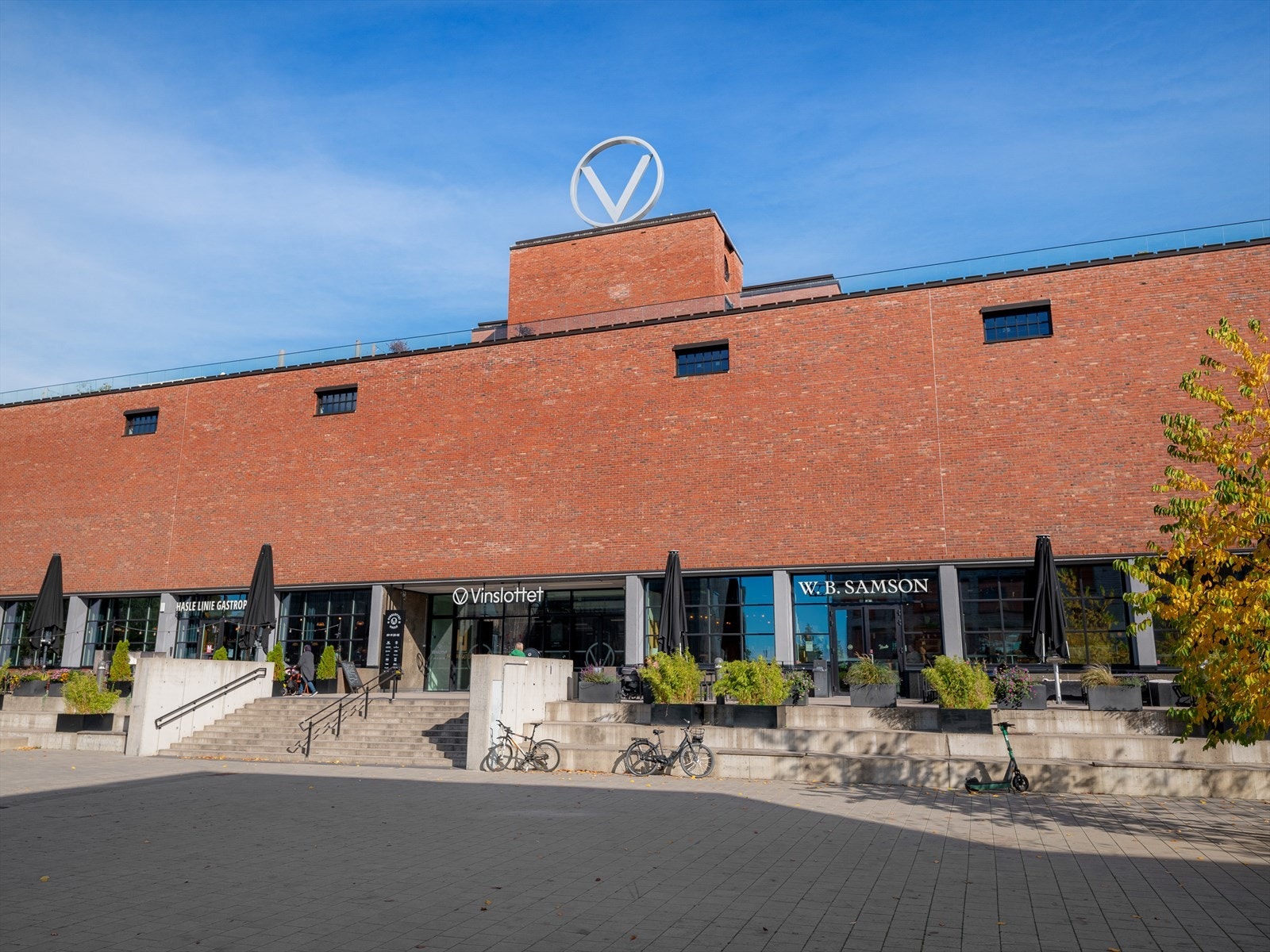 Fasadebilde av Vinslottet med butikker i første etasje som normal, jysk, 8sushi, synsam, matbutikk m.m. Galleribilde
