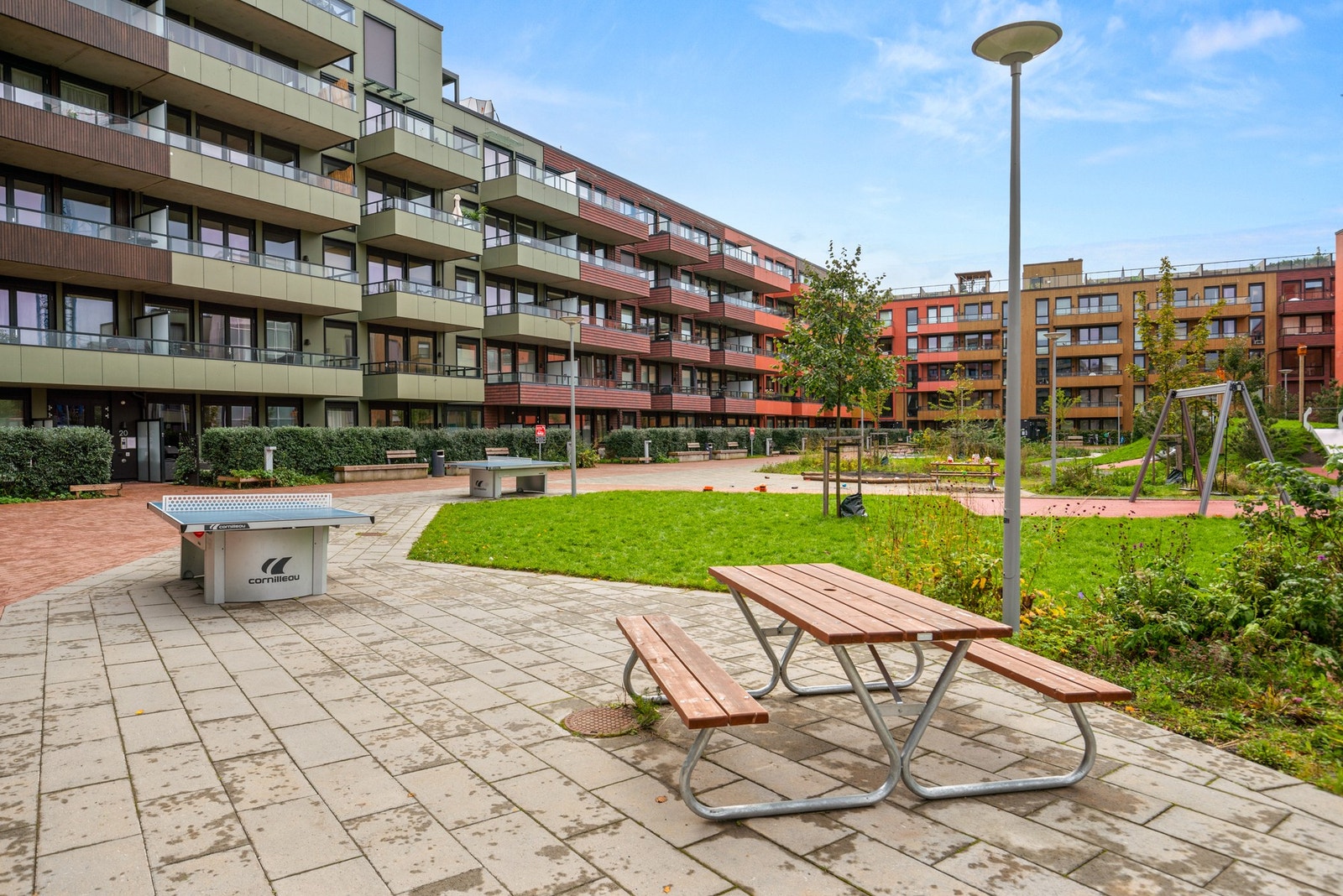 Bakgården er pent opparbeidet med grønne arealer og tilrettelagt for sosiale aktiviteter. Galleribilde