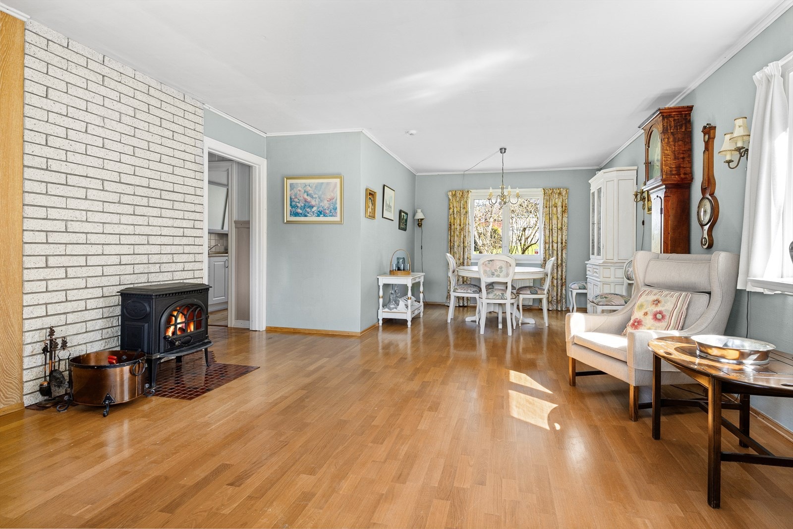 Stuen i første etasje har plass til både spisebord og sofagruppe. Vedovnen gir ekstra varme. Galleribilde