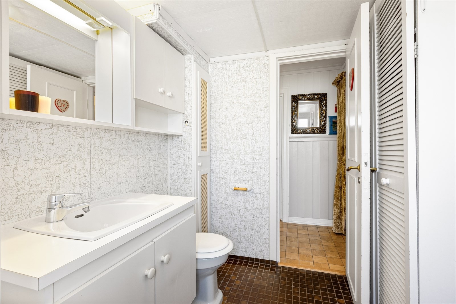 Badet i første etasje er fra byggeåret, med flislagt gulv og plater på veggene. Galleribilde