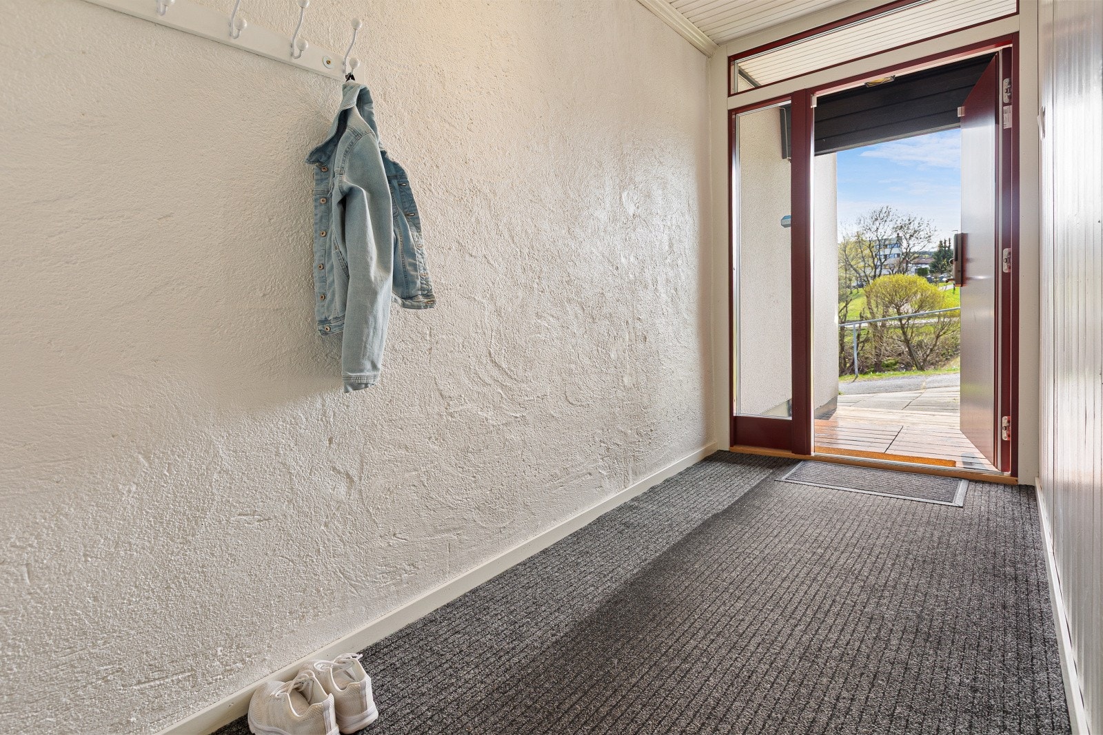 Velkommen inn i en romslig entré med plass til yttertøy og sko. Ytterdøren er fra 2018. Galleribilde