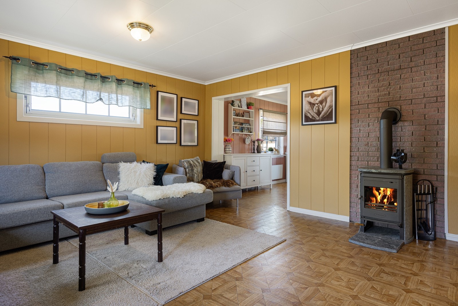 Utenfor spisestuen ligger hovedstuen. Her er det en klebersteinsovn gir ekstra varme og hygge til rommet. Galleribilde
