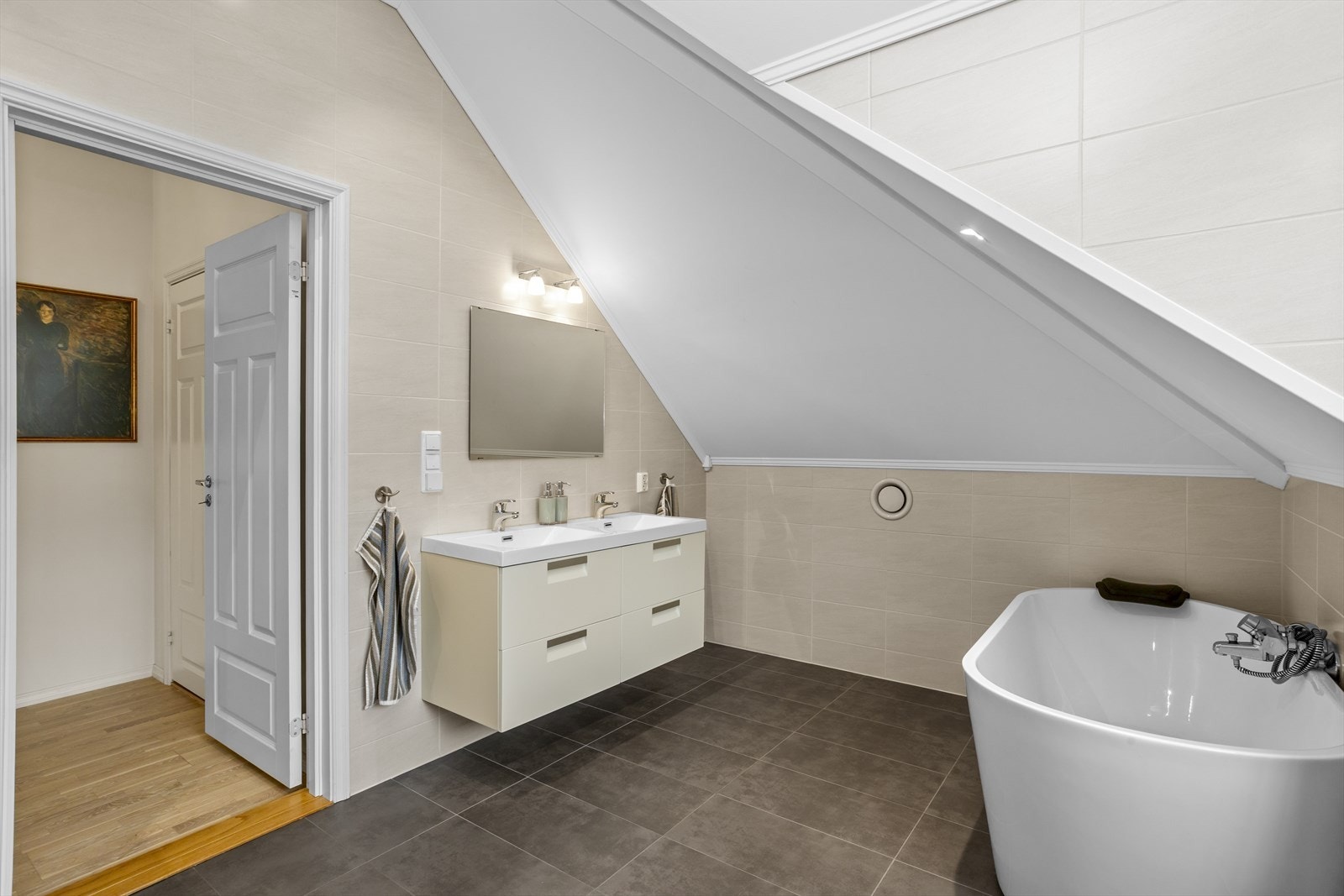 Badet er utstyrt med dobbel servant i innredning, badekar og vegghengt toalett. Galleribilde