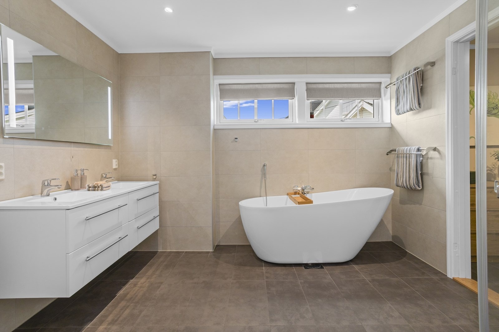 Badet i første etasje er helfliset og utstyrt med både badekar og dusjnisje. Rommet har gulvvarme. Galleribilde