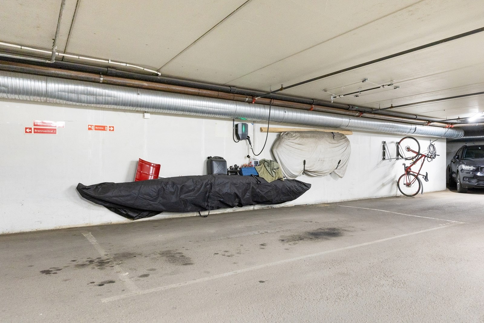 Det medfølger en særdeles romslig garasjeplass med installert elbillader, med god plass til større bil som SUV - blant de største plassene i sameiet. Garasjeanlegget er oppvarmet og har direkte heisadkomst fra toppetasjen. Galleribilde