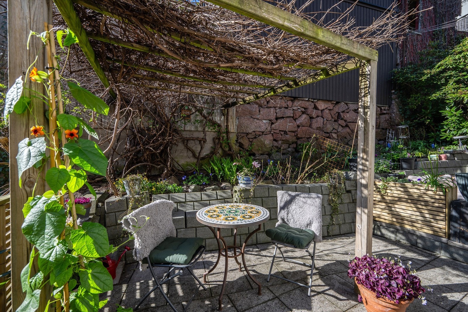 Terrassen er delvis overbygget av en pergola, som gir en hyggelig ramme for uteplassen. Galleribilde