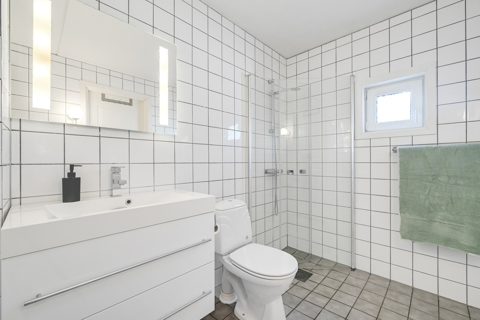Badet i første etasje har flislagte overflater på gulv og vegger. Galleribilde