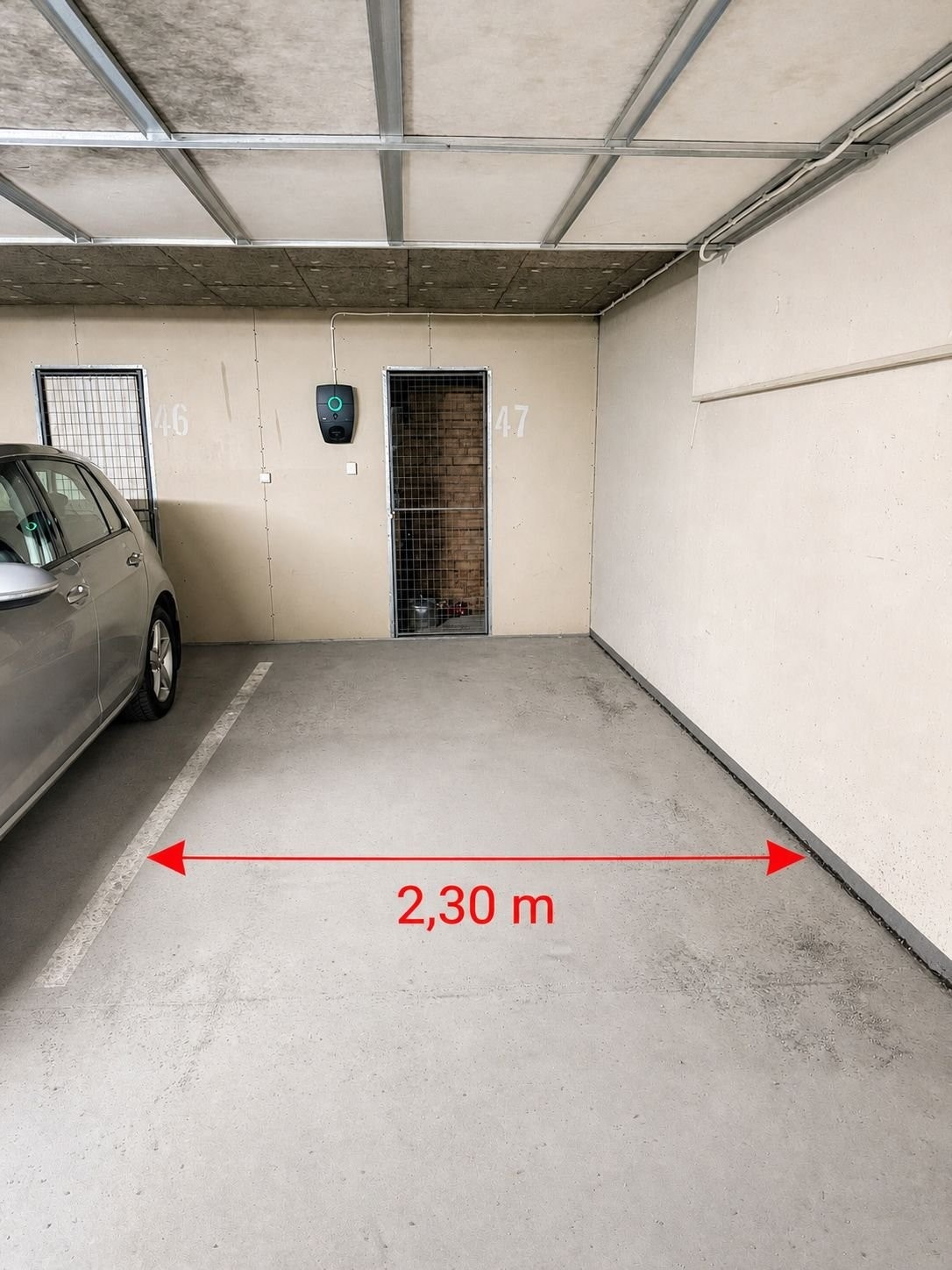 Garasje med 2,30m mellom betongvegg og hvitstripe. El-billader og bod på 2,6m2. Galleribilde