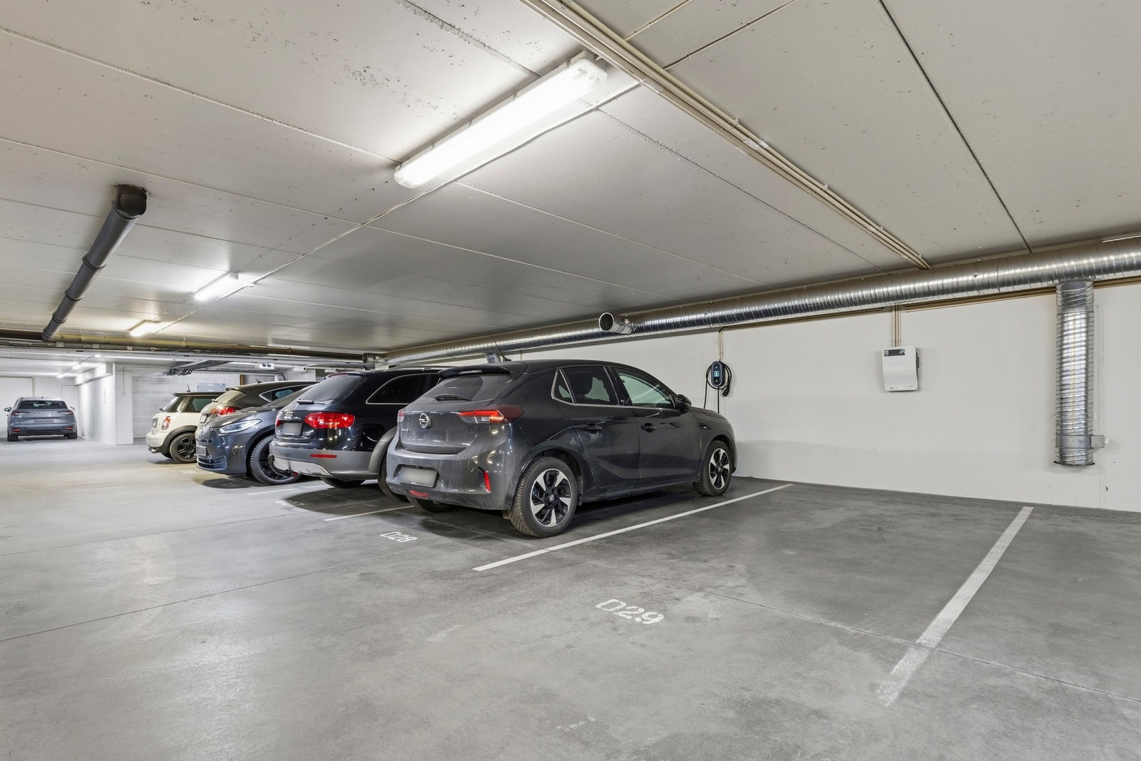 Parkeringsplass i kjeller med elbillader, tilhørende Frydenberg Garasjesameie C og D. Galleribilde