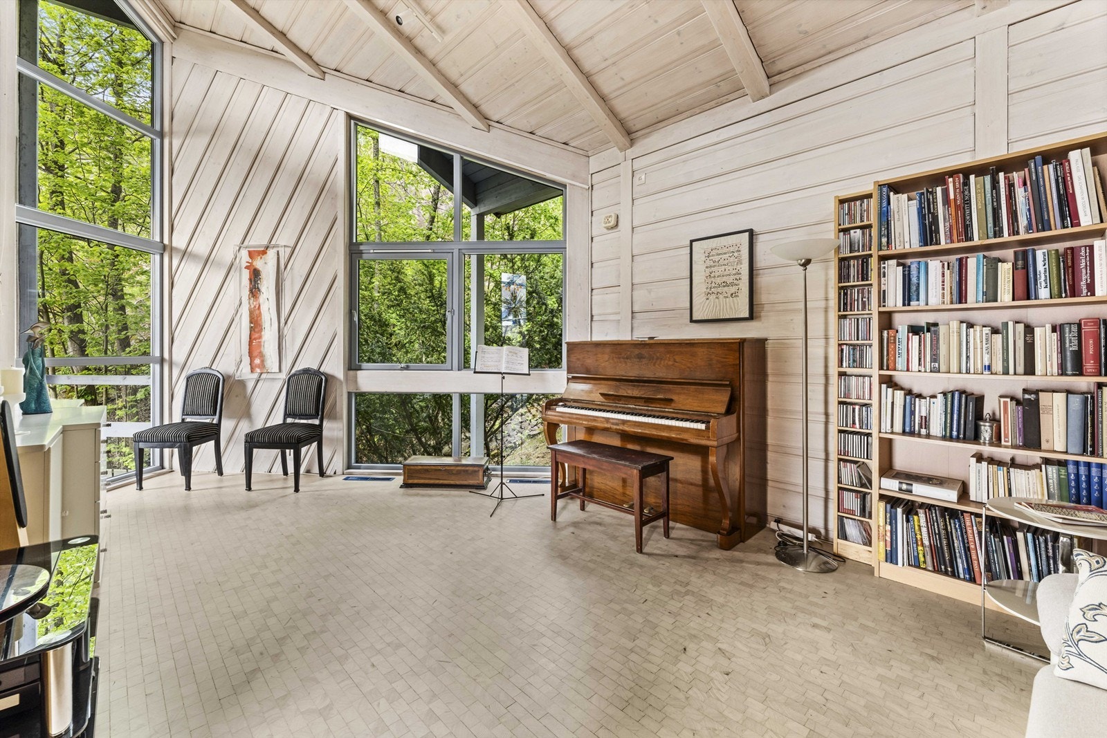 Musikkrom/bibliotek med god takhøyde og store vindusflater mot naturen. Galleribilde