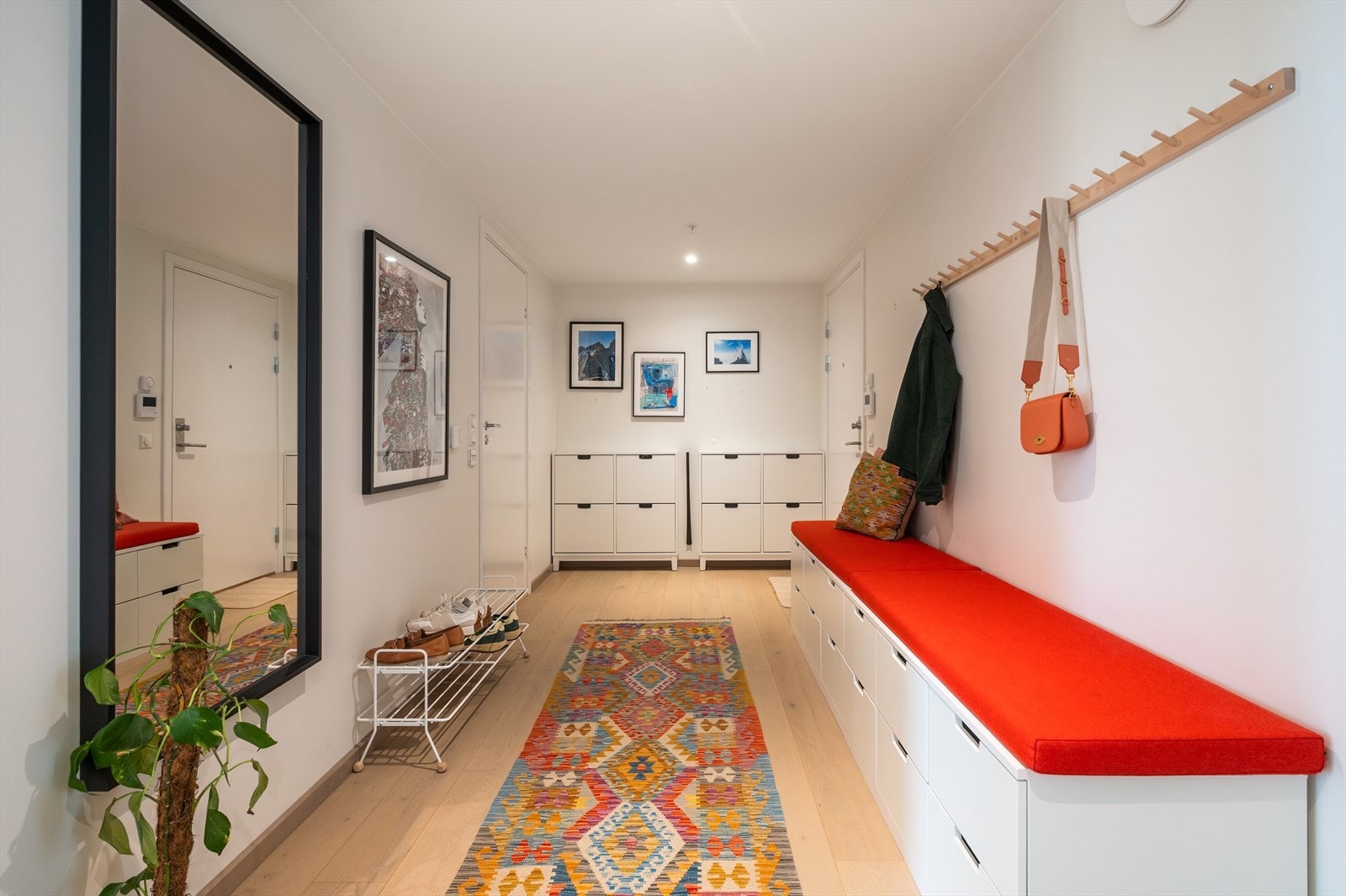 Stor entre/gang med god plass til oppbevaring. Den er i dag innredet med lang oppbevaringsbenk, romslige skuffer og knaggrekke for yttertøy. Galleribilde