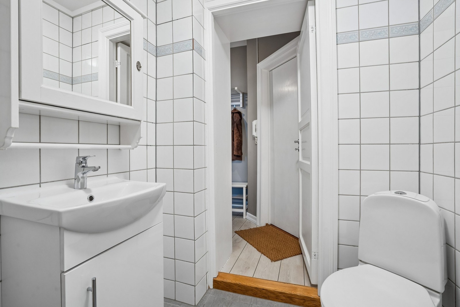 Badet er innredet med dusjhjørne, toalett, servantinnredning og speilskap. Oppsett for vaskemaskin finnes. Galleribilde