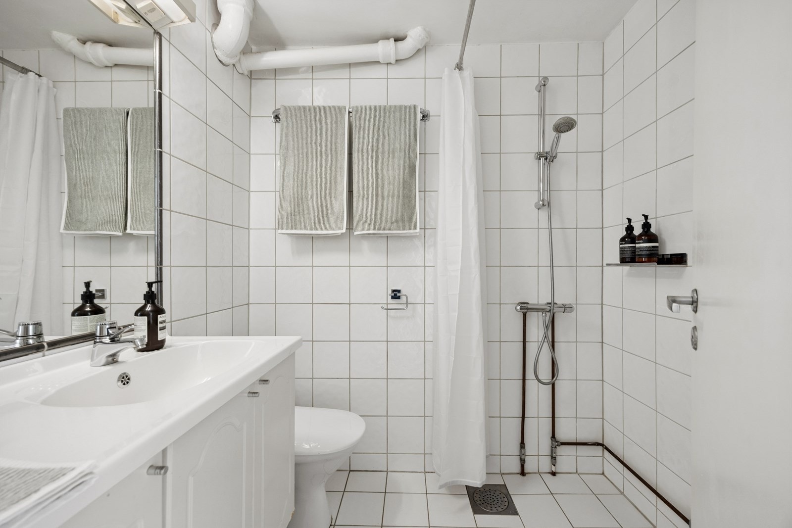 Badet har en tidløs fargepalett og er tilrettelagt med opplegg for vaskemaskin. Galleribilde