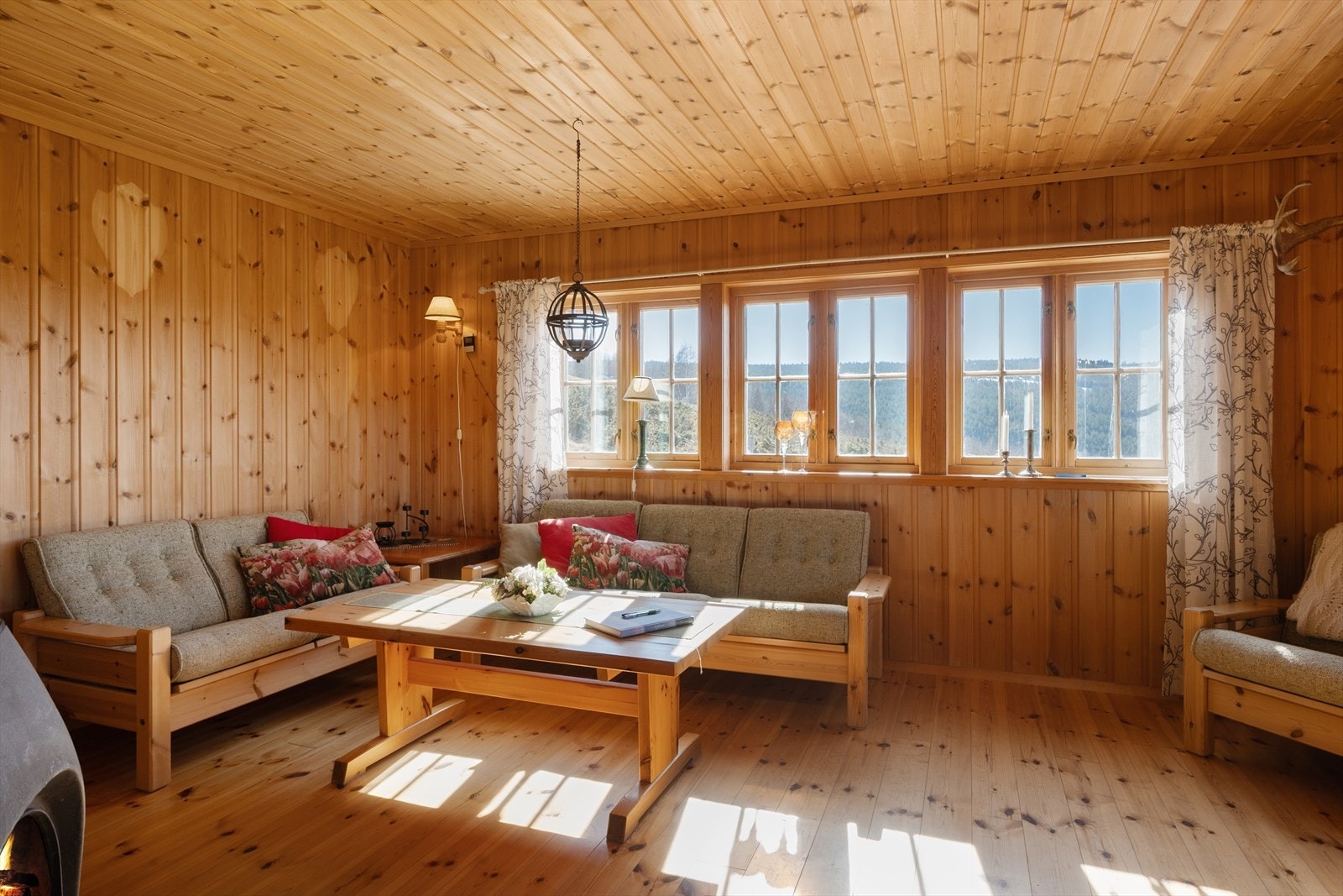Vinduene i stua rammer inn utsikten mot fjellandskapet. Galleribilde