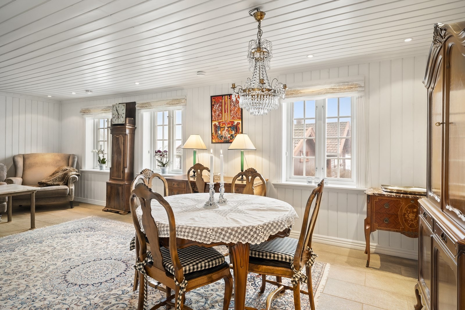 Stue med utsyn mot omkringliggende trehusbebyggelse og fjorden. Galleribilde