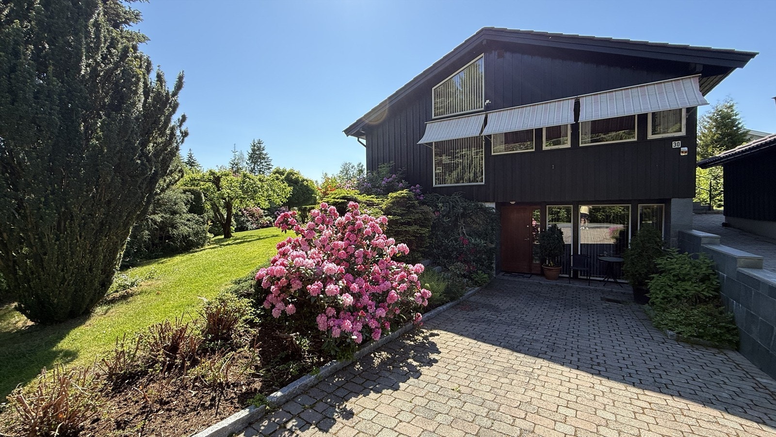 Eiendommen har en frodig og velstelt hage med beplantning som blomstrer gjennom sesongen. (Privat sommerbilde.) Galleribilde