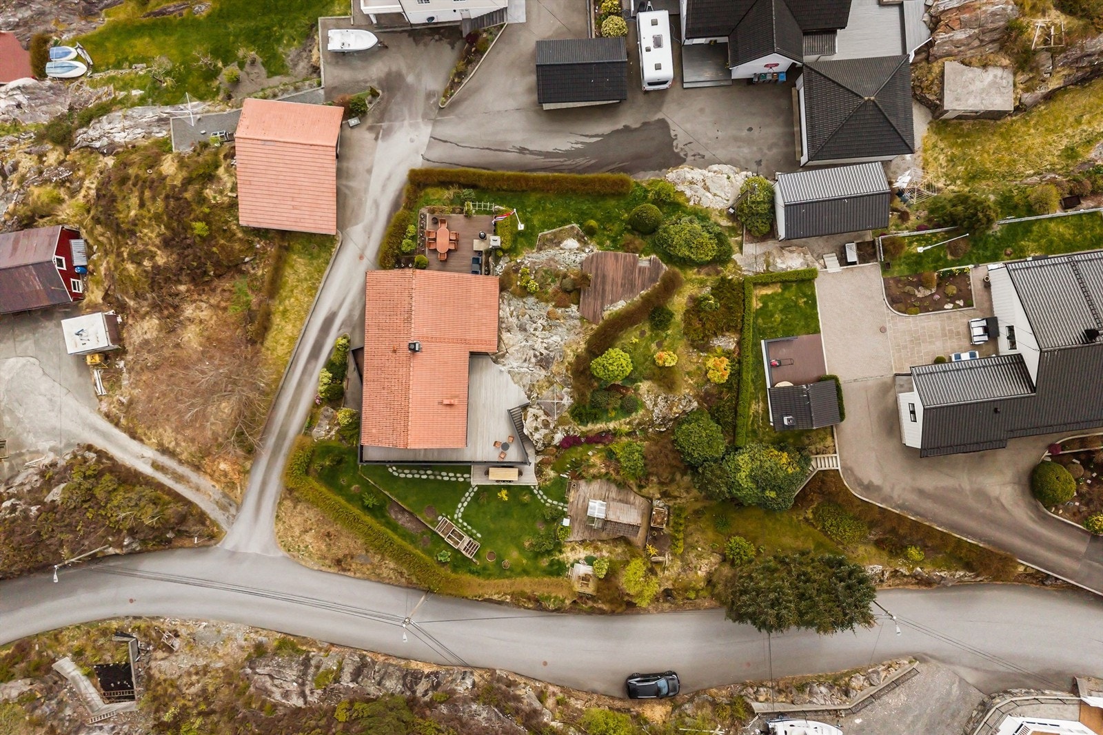 Tomten er godt utnyttet med terrasser, plen og beplantning som rammer inn boligen. Galleribilde