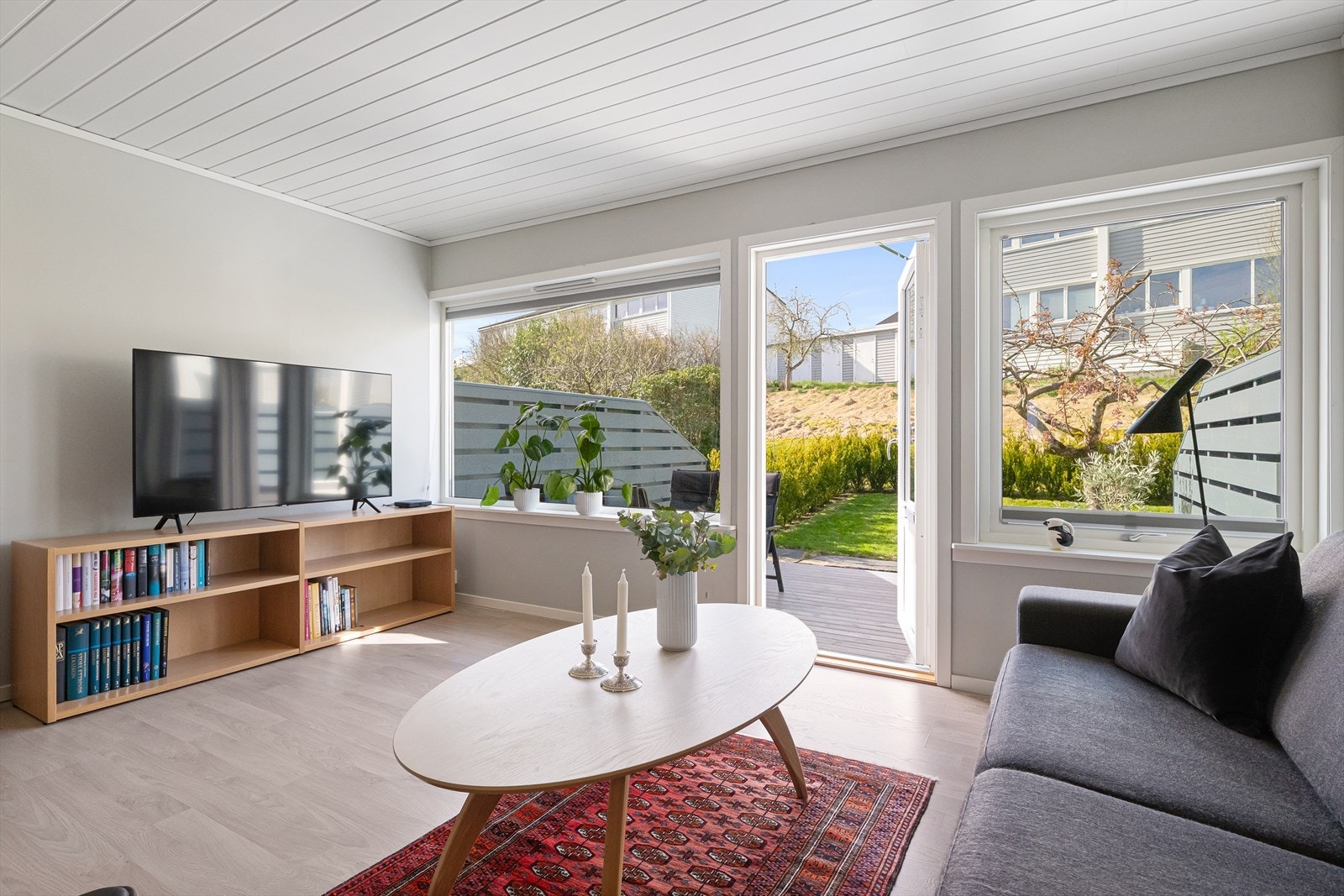 Stuen har store vindusflater og dør ut til terrassen, som visker ut skillet mellom inne og ute. Galleribilde